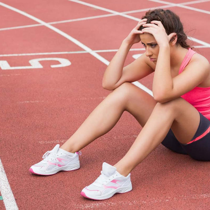 Tired runner sitting on an athletics track