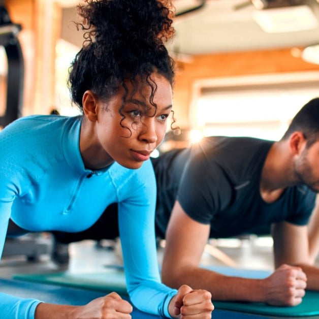People doing forearm planks in a gym class